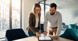 IT manager and network engineer reviewing a phased SASE migration plan in a bright Brussels office.