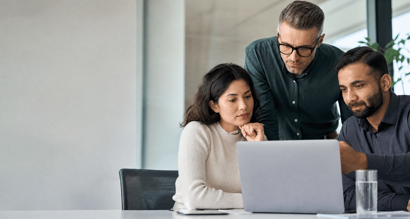IT team reviewing SASE proof-of-concept results on a laptop in a modern meeting room