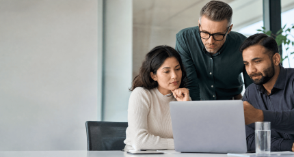 IT team reviewing SASE proof-of-concept results on a laptop in a modern meeting room