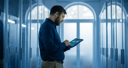 IT engineer reviewing network activity in a European server room.