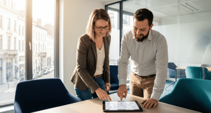IT manager and network engineer reviewing a phased SASE migration plan in a bright Brussels office.